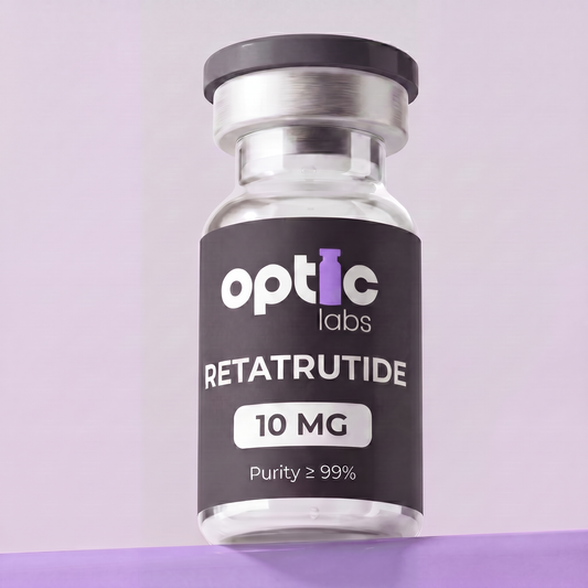A small glass vial labeled Optic Labs Retatrutide (5mg–30mg) sits on a purple surface with a light purple background. The vial has a silver cap and a black label featuring white and purple text. Optic Labs Au